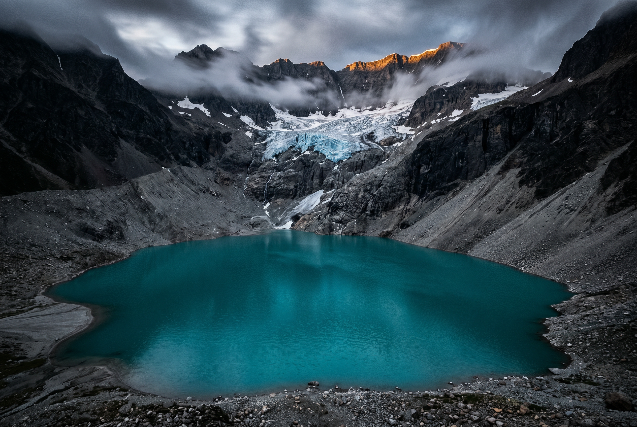 Turquoise glacial lake ringed by grey peaks and a hanging glacier in Alberta